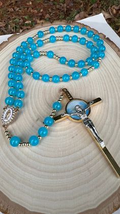 "Rosary to the Holy Spirit made with 8mm Glass Blue beads, 6mm gold spacers were used, the centerpiece is Our Lady of Guadalupe of 1\" or 2 cm. The wire that was used 7 strand Satin Copper, the crucifix of the rosary is of the Holy Spirit On the front and on the back is the sacred heart of Jesus, it measures 3.5\" or 9 cm. The total measurement of the rosary is 20\" or 51cm. Beautiful instrument of prayer or to give as a gift." Spiritual Rosary With 8mm Beads For Blessing, Spiritual Beaded Rosary For Blessing, Turquoise Spiritual Rosary Bracelet With Round Beads, Spiritual Turquoise Rosary Bracelet With Round Beads, Turquoise Rosary Bracelet With Round Beads, Spiritual Turquoise Rosary With Round Beads, Turquoise Rosary With Round Beads, Spiritual Rosary With Colorful Beads As Gift, Spiritual Colorful Beads Rosary As Gift