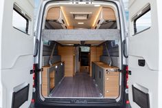 the interior of a van with its doors open and wood flooring in front of it