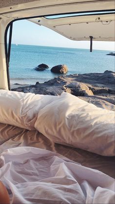 the view from inside a van looking out at the ocean and rocks in the water