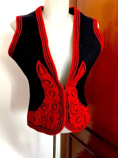 "Authentic Hungarian vest with sewn red Kalotaszeg pattern on it. Unique black and red soft felt folk vest with accessories : a purse, a key case, a doily, a documents case. The pattern is called IRASOS-\"written\" embroidery, a true expression of Kalotaszeg and Transylvanian culture and the pride of its people. Size S" Red Wool Vest For Winter, Bohemian Black Embroidered Vest, Traditional Red Vest For Festival, Traditional Black Sleeveless Vest, Red Embroidered Sleeveless Vest, Winter Bohemian Black Vest, Black Folk Style Festival Vest, Traditional Black Vest For Festival, Traditional Fitted Black Vest