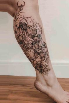 a woman's leg with tattoos on it and flowers in the middle of her legs