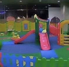 children's play area in an office building with slide and climbing equipment on the ground