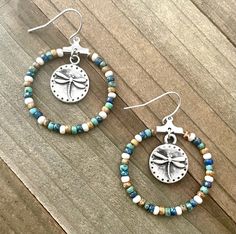 These tan and turquoise seed bead hoops are so pretty! The colors of blue and white are also present.  The dragonfly dangling from the mddle gives these hoops character.  They are the perfect dangling hoop earrings.  These hoops are 30 mm (1.1/8 inches) in diameter and very light on the ears.  These handmade lovelies would be great as a gift or something for you to treat yourself with. ~I use high quality hypoallergenic materials along with many different glass seed beads.  I work hard to create Bohemian Heishi Beads Small Hoop Earrings, Bohemian Small Hoop Heishi Bead Earrings, Nickel-free Hoop Earrings With Heishi Beads, Bohemian Heishi Beads Hoop Earrings As Gift, Bohemian Hoop Beaded Earrings With Heishi Beads, Bohemian Heishi Beads Hoop Earrings, Bohemian Heishi Beaded Hoop Earrings, Bohemian Hoop Earrings With Heishi Beads, Bohemian Round Hypoallergenic Beaded Earrings