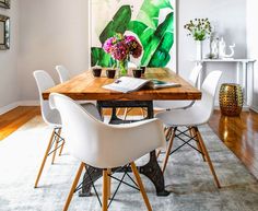 a dining room with white chairs and a wooden table