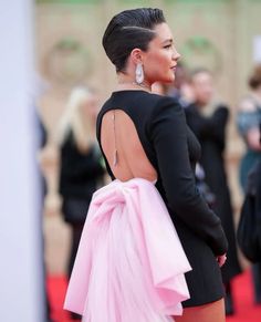 the back of a woman's dress as she walks on a red carpet