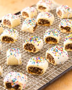 there are many desserts that have been cut in half on a cooling rack with sprinkles