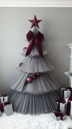 a christmas tree made out of pleated paper with red and silver ornaments around it