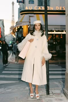 Prepare to be wrapped in luxury in the ever-so gorgeous Nina Coat. This long-line wool coat has an A-shaped silhouette to give you a bit of style in addition to warmth. The faux fur sleeves and neckline add a chic edge, and when paired with the custom jewel buttons, the entire coat cannot be replicated. Fall Outfits Luxury, White Dress With Sleeve, Fur Dress Coat, How To Wear A Wrap, 2024 Runway Fashion, Winter Fancy Outfits, Coat Over Dress, Coat For Dress, All White Winter Outfit