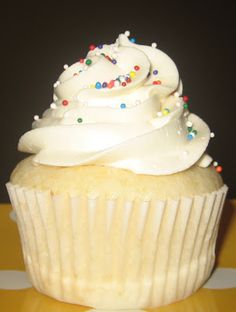 a cupcake with white frosting and sprinkles