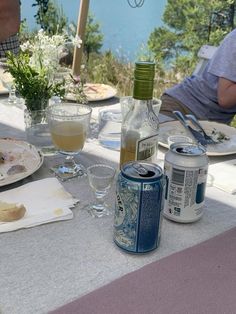 an outdoor table with food and drinks on it