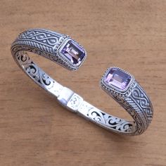 Capped by 5.5 carats of sparkling amethyst gemstones this cuff bracelet from Bali is designed by Wayan Neri. The cuff is crafted of sterling silver with intricate helix patterns. On the inside of the bracelet are hidden openwork vine motifs. This bracelet opens with a concealed hinge to fit the wrist. Bracelet Silver For Men, Silver For Men, Hand Cuff Bracelet, Fashionable Accessories, Jewelry Set Design, Tibetan Jewelry, Blue Topaz Earrings, Handcrafted Bracelets, Amethyst Jewelry