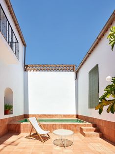 an empty patio with a chair and table