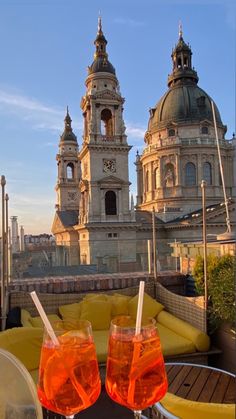 two drinks sitting on top of a table next to each other in front of a building