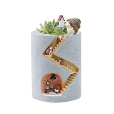 there is a planter with animals in it on the top of a tube shaped like a house