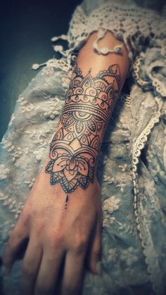 a woman's arm with an intricate tattoo on the left side of her arm