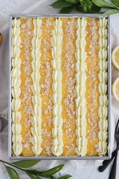 a close up of a cake on a table with lemons and utensils