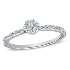 a white gold ring with diamonds on the band and an oval shaped diamond in the center