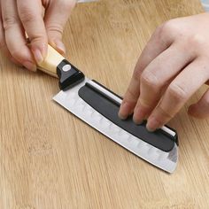 a person using a knife to cut something on a cutting board with a wooden handle