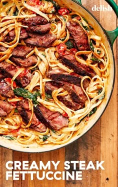 a pan filled with meat and noodles on top of a wooden table