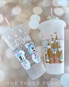 two plastic cups with designs on them sitting next to each other