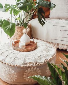 a plant in a basket sitting on top of a wooden table next to a couch