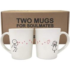 two mugs sitting next to each other in front of a box with stick figures on them