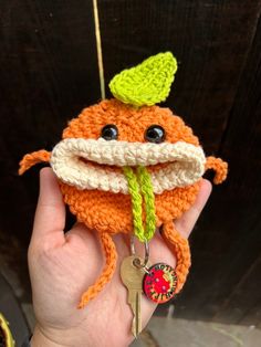 a crocheted orange stuffed animal with a green hat on it's head