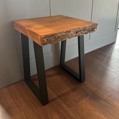 a wooden table sitting on top of a hard wood floor next to a white wall