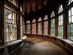 an empty room with large windows and wood flooring