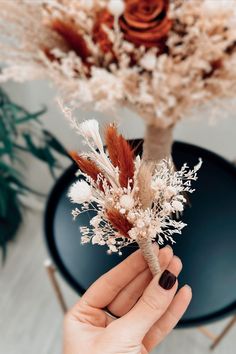 a person holding a dried flower in their hand