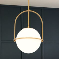 a light fixture hanging from the ceiling in a room with dark blue walls and wooden paneling