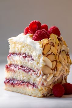 a piece of cake with raspberries and almonds on top