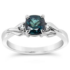 an engagement ring with a blue topazte and white diamonds on the sides, set in