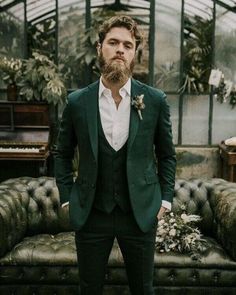 a man with a beard standing in front of a couch