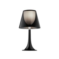 a black lamp with a white shade on the base and a light in the middle