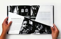 two hands holding an open book with black and white photos