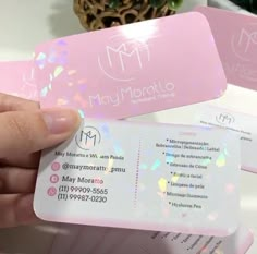 a person holding up a pink business card