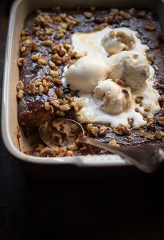 a casserole dish with ice cream and walnuts on top, ready to be eaten