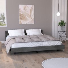 a bed sitting in the middle of a bedroom next to a white rug on top of a hard wood floor