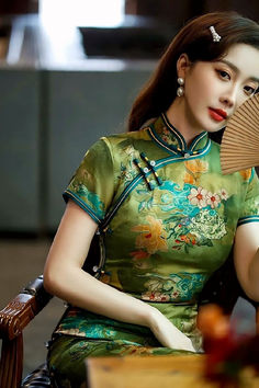 Green qipao dress with a traditional style and a standing mandarin collar Green Stand Collar Cheongsam For Spring, Spring Green Cheongsam With Stand Collar, Green Elegant Cheongsam With Stand Collar, Elegant Green Cheongsam With Stand Collar, Green Dresses For Tea Ceremony, Elegant Green Dress For Traditional Ceremonies, Green Spring Wedding Cheongsam, Spring Wedding Green Cheongsam, Traditional Dresses For Tea Ceremony