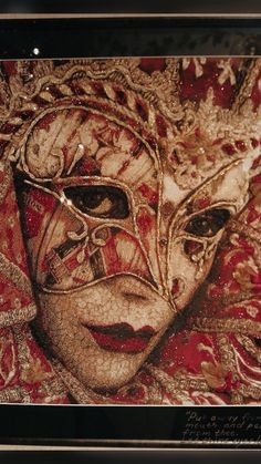 a painting of a woman's face with red and gold designs on her face