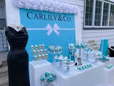 a table topped with lots of cupcakes next to a sign that says carlly & co