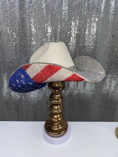 The “America” hat is perfect for your summer on the lake, BBQs, Labor day weekend, rodeos, and any events you may be attending! This hat will feature the American Flag print on the bottom. Choose whether you want crystal rhinestones on the top brim as well, or leave it plain with the crystal hat band that comes with it! **Please note - due to the bright colors on the American flag hat, they can fade over time, especially if they are exposed to rain or water** This hat features: Sand square shape Americana Rodeo Hat With Curved Brim, High Crown Hats For Summer Rodeo, Americana Curved Brim Hat For Rodeo, Americana Style Curved Brim Hat For Rodeo, Curved Brim Hats For Country Festivals, High Crown Hats For Summer Country Events, Summer High Crown Hats For Country Events, Western Style High Crown Hat For Summer, Western Style High Crown Summer Hat