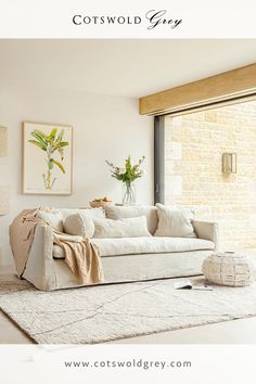 a living room with a white couch and rugs next to a glass door that opens onto an outside patio