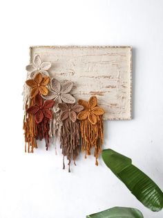 the wall hanging is decorated with flowers and fringes