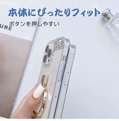 a person holding a cell phone with a ring on it's finger and an advertisement in japanese