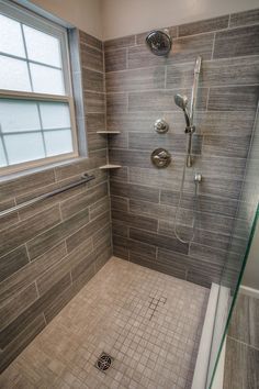 a walk in shower sitting under a window next to a sink and bathtub covered in tile