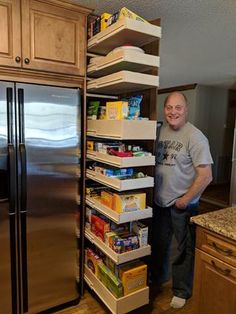 a man standing in front of a refrigerator with food on the bottom shelf and shelving behind it