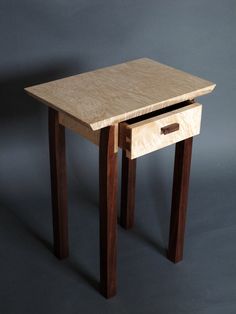 a small wooden table with one drawer open