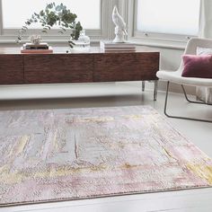 a living room area with a rug, chair and table in front of a window